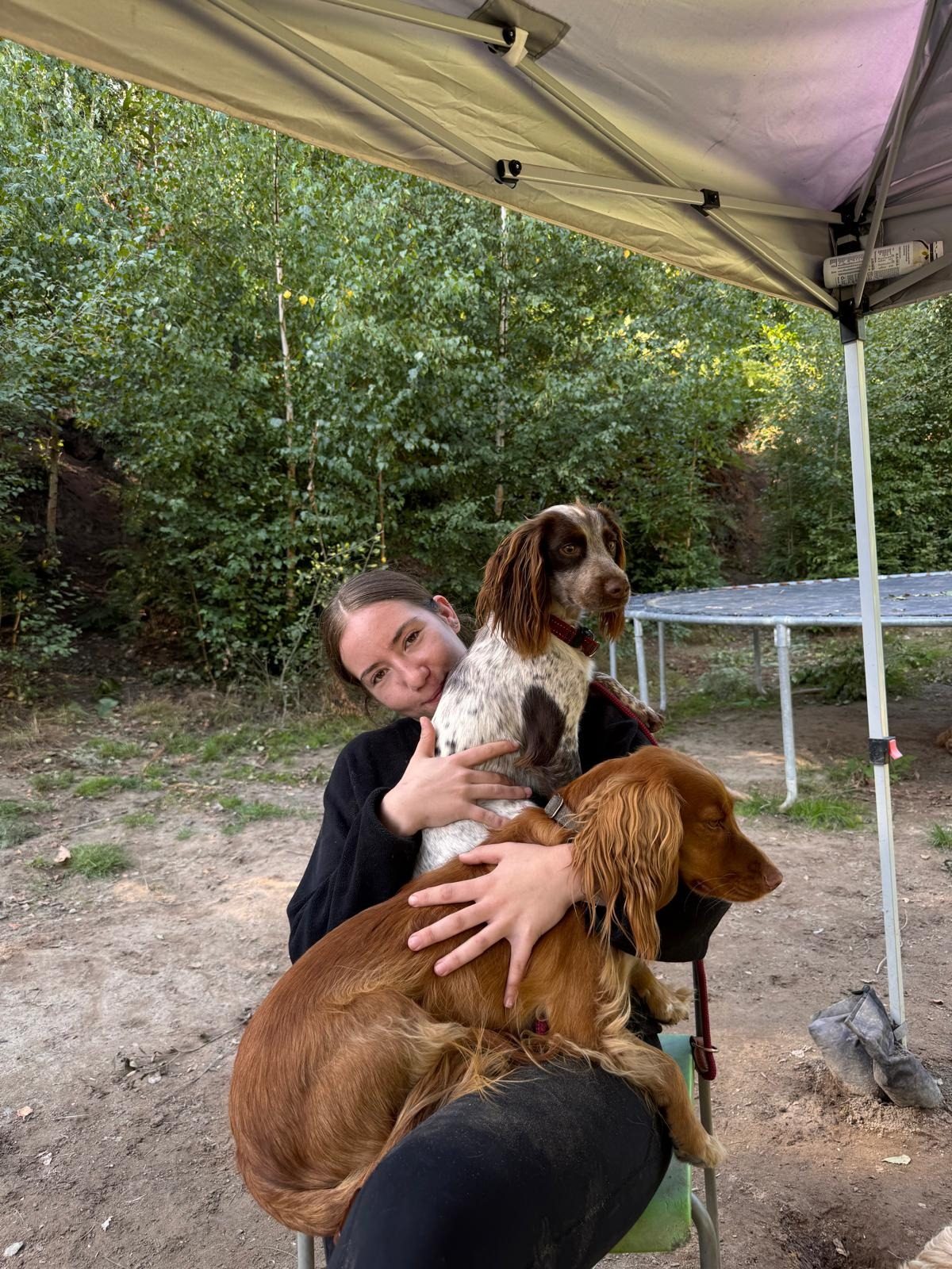 A team member crouched with a spaniel at the end of the day