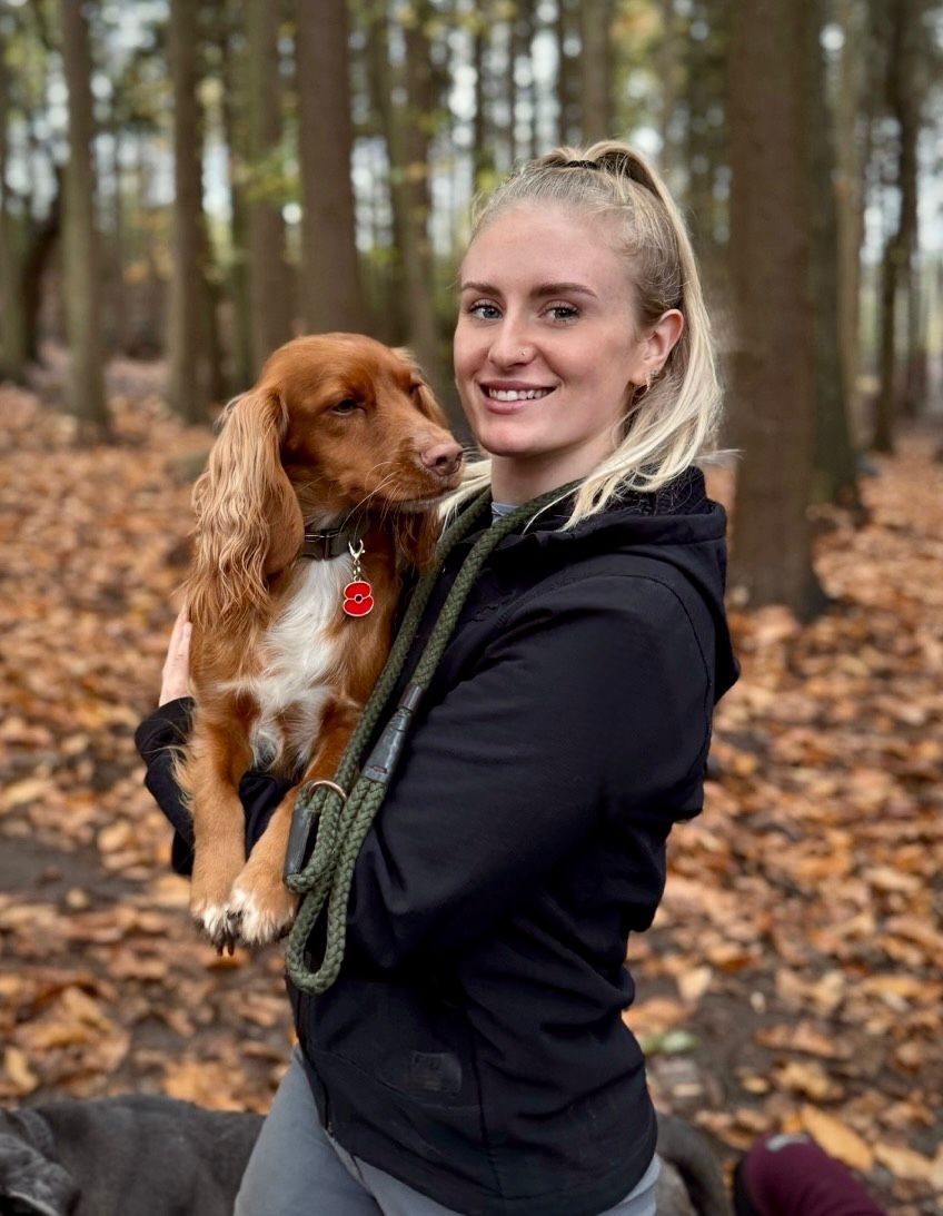 Laura, one of the Duncan's Dog Co. drivers, in the woodland with a spaniel